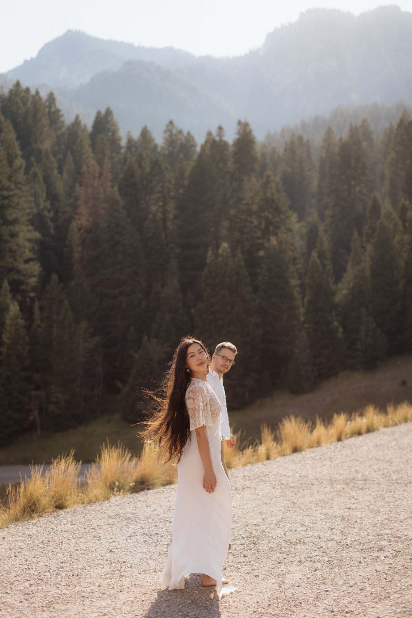 Dr. Arman and her husband on a sunlit mountain road among the pines